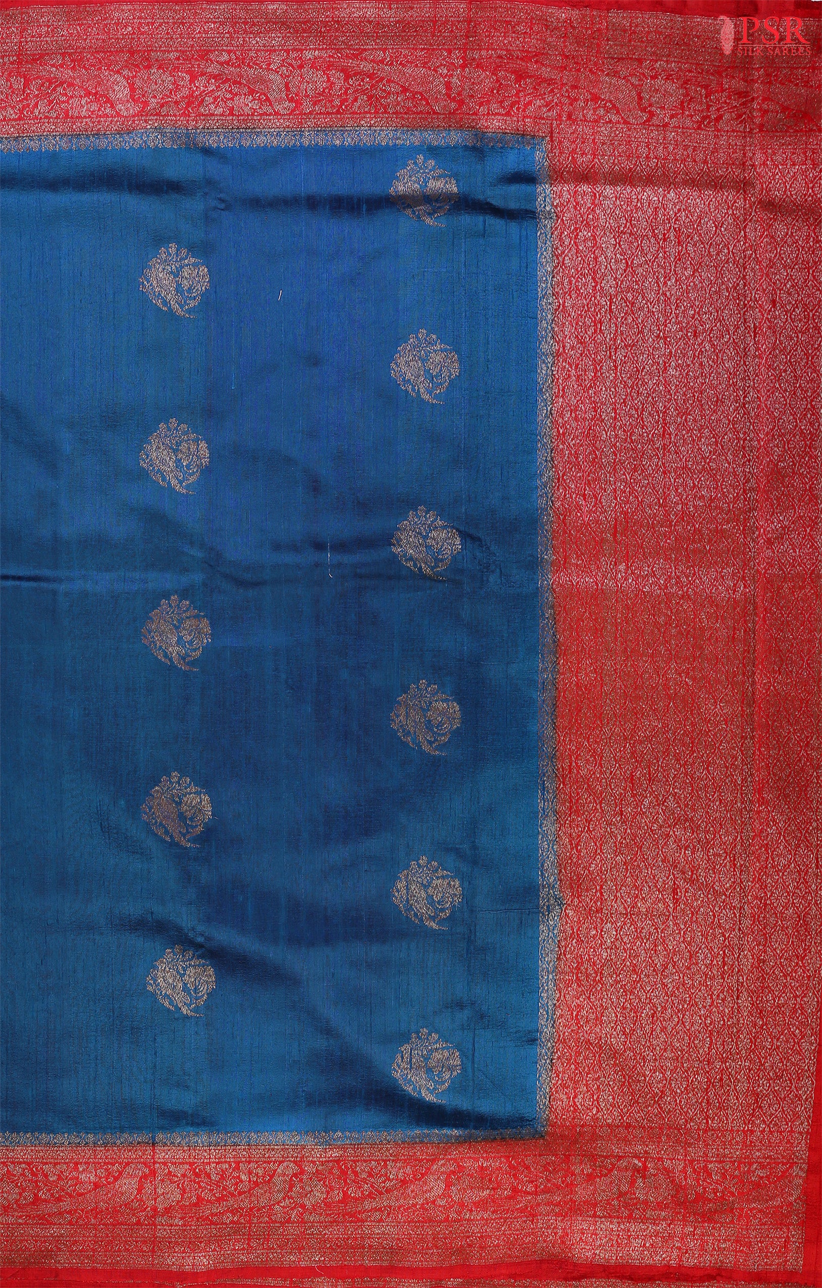 Unveil a world of elegance with this stunning Peacock Blue Banaras Jute Silk Saree, beautifully paired with a vibrant Red accent.