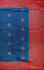 Unveil a world of elegance with this stunning Peacock Blue Banaras Jute Silk Saree, beautifully paired with a vibrant Red accent.