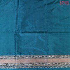 PSR Silks presents a stunning Peacock Blue Banarasi Silk Saree, showcasing a masterfully woven zari lattice pattern, beautifully embellished with vibrant thread work.