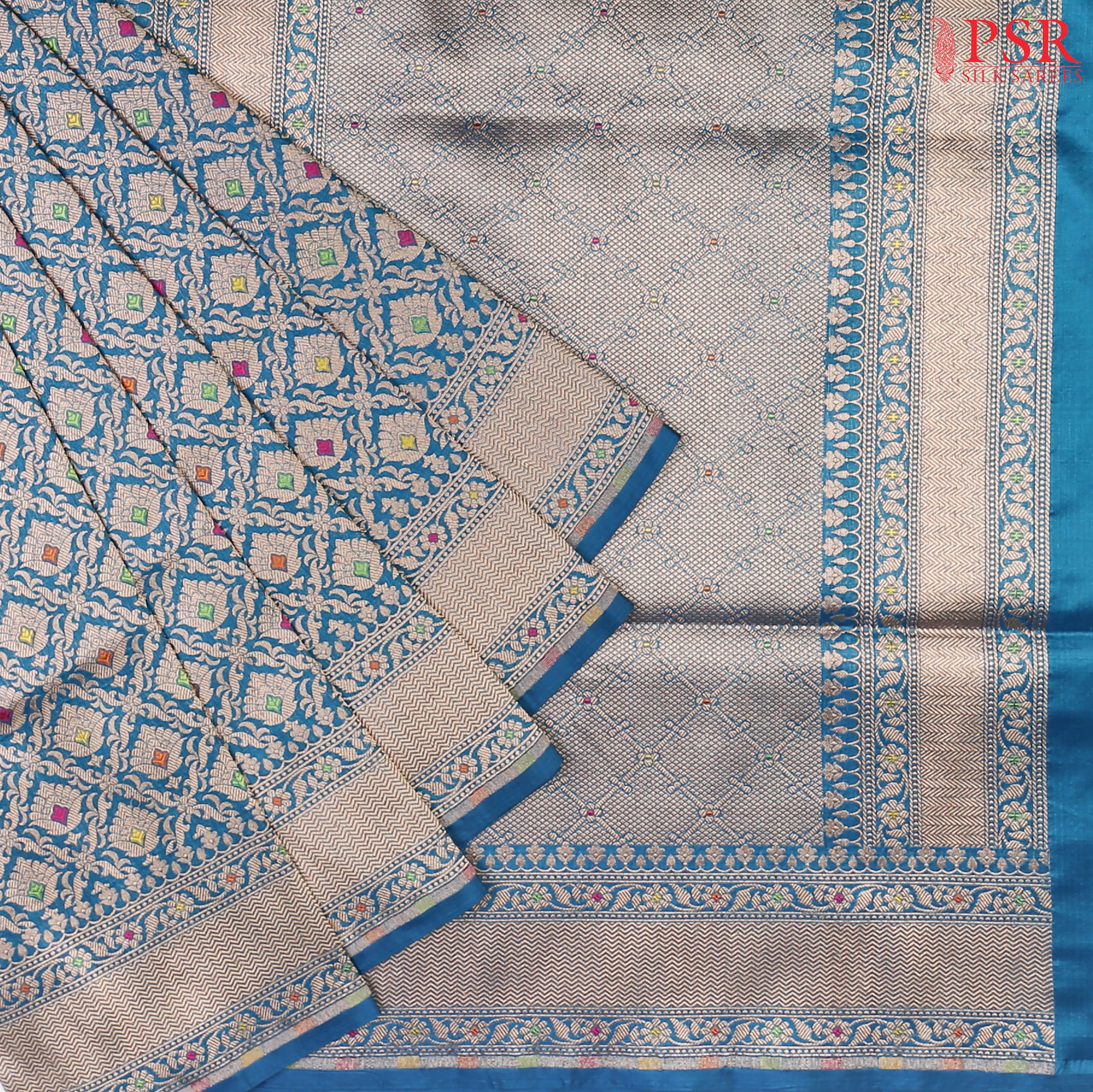 PSR Silks presents a stunning Peacock Blue Banarasi Silk Saree, showcasing a masterfully woven zari lattice pattern, beautifully embellished with vibrant thread work.