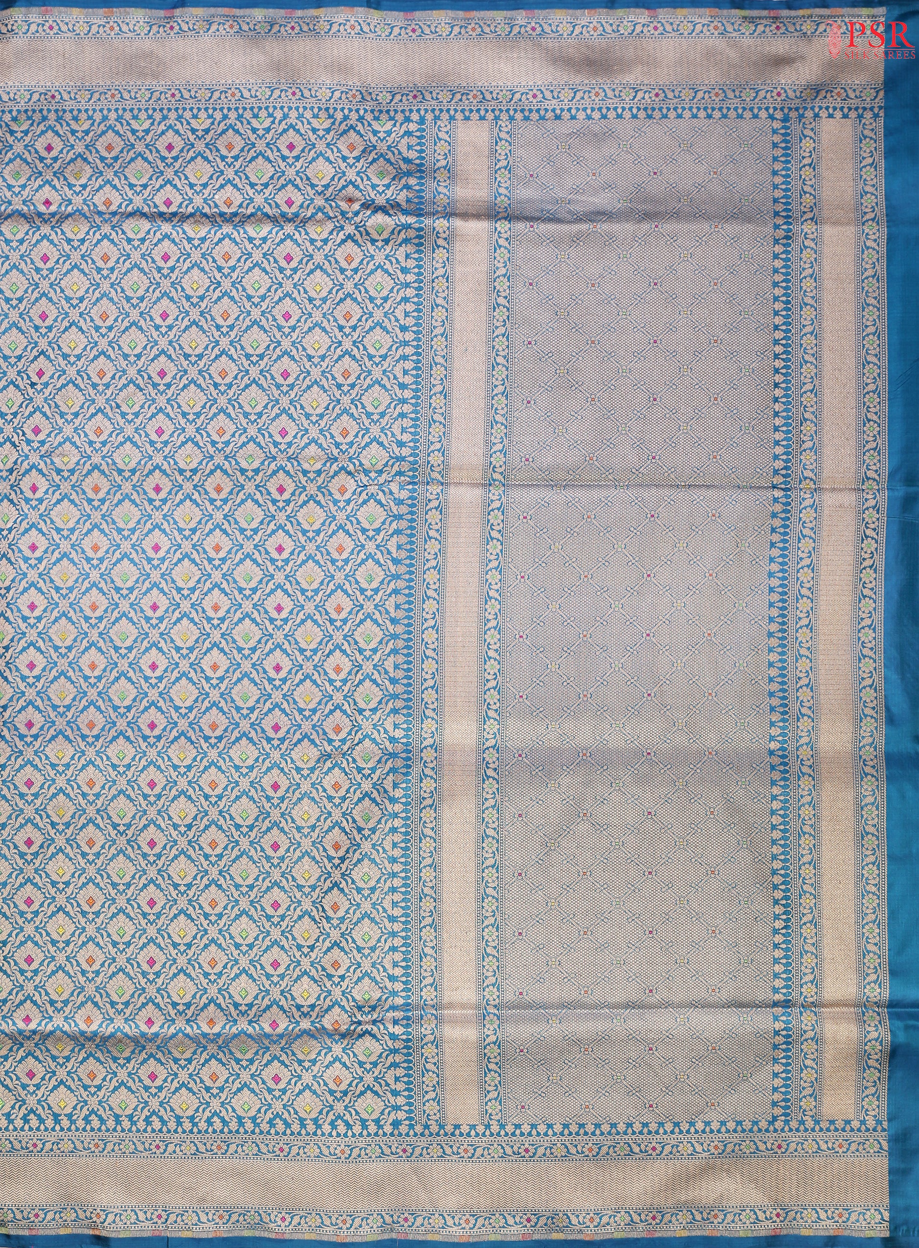 PSR Silks presents a stunning Peacock Blue Banarasi Silk Saree, showcasing a masterfully woven zari lattice pattern, beautifully embellished with vibrant thread work.