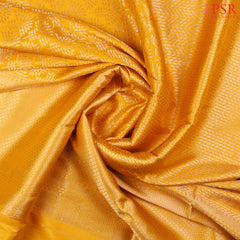 PSR Silk Sarees presents an elegant Amber Yellow Banaras Silk Saree, a masterpiece of heritage and craftsmanship.