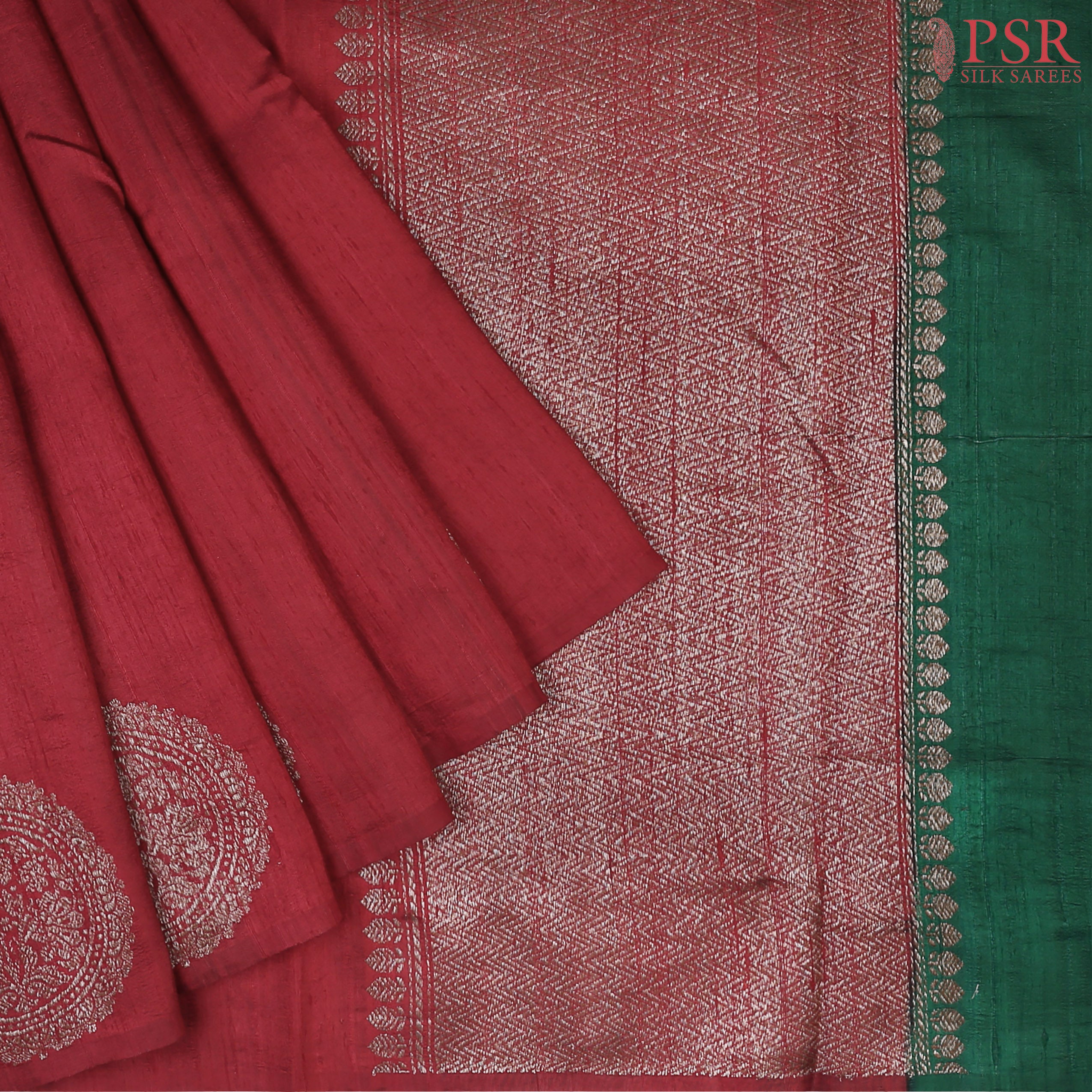PSR Silks unveils a magnificent Berry Red Banaras Jute Silk Saree, beautifully paired with a luxurious Dark Green combination. 