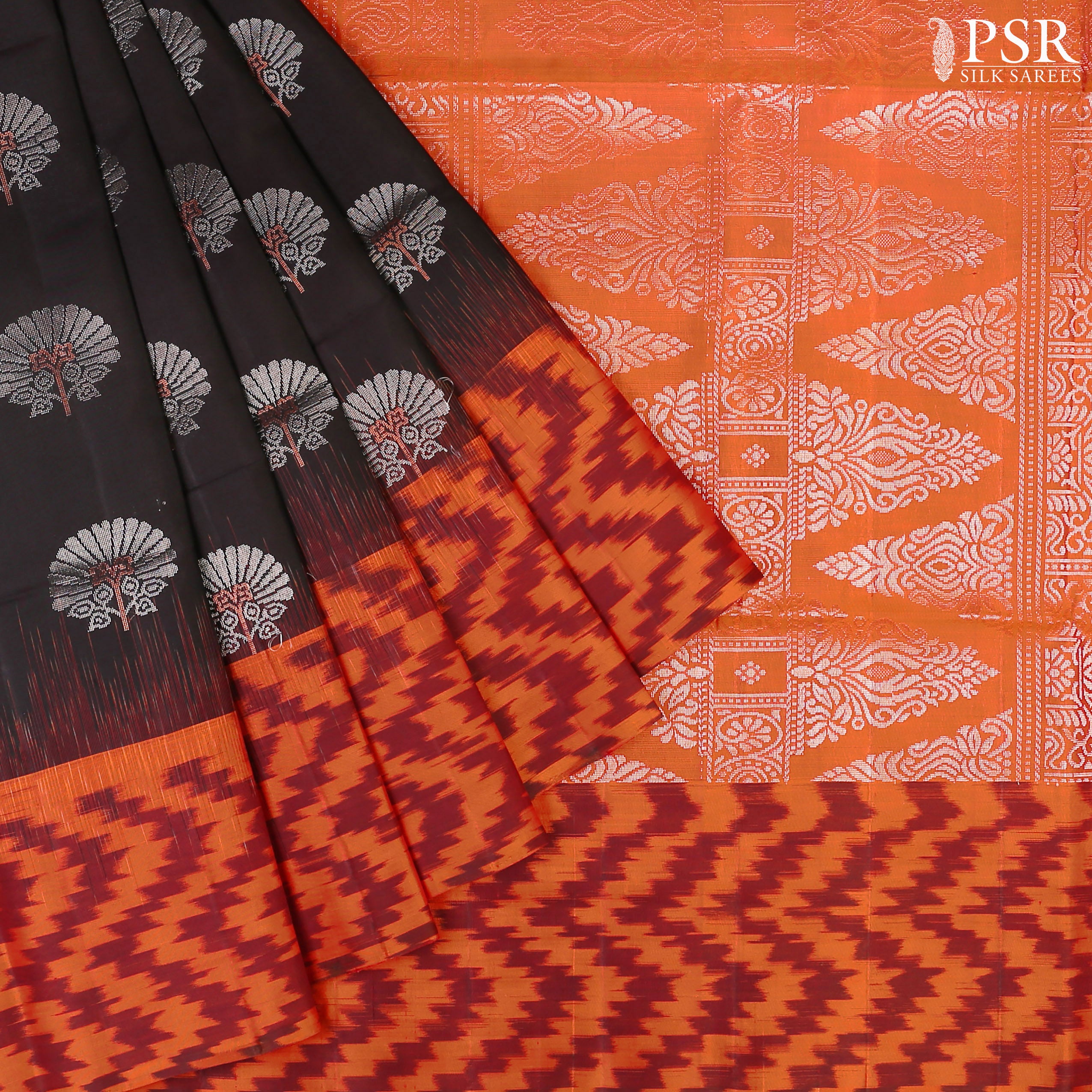 Embrace sophistication with PSR Silks' enchanting Black Soft Silk Saree, perfectly paired with a vibrant Lava Orange combination. This elegant saree is adorned with intricate silver and copper zari floral motifs, radiating timeless beauty.