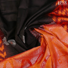 Embrace sophistication with PSR Silks' enchanting Black Soft Silk Saree, perfectly paired with a vibrant Lava Orange combination. This elegant saree is adorned with intricate silver and copper zari floral motifs, radiating timeless beauty.