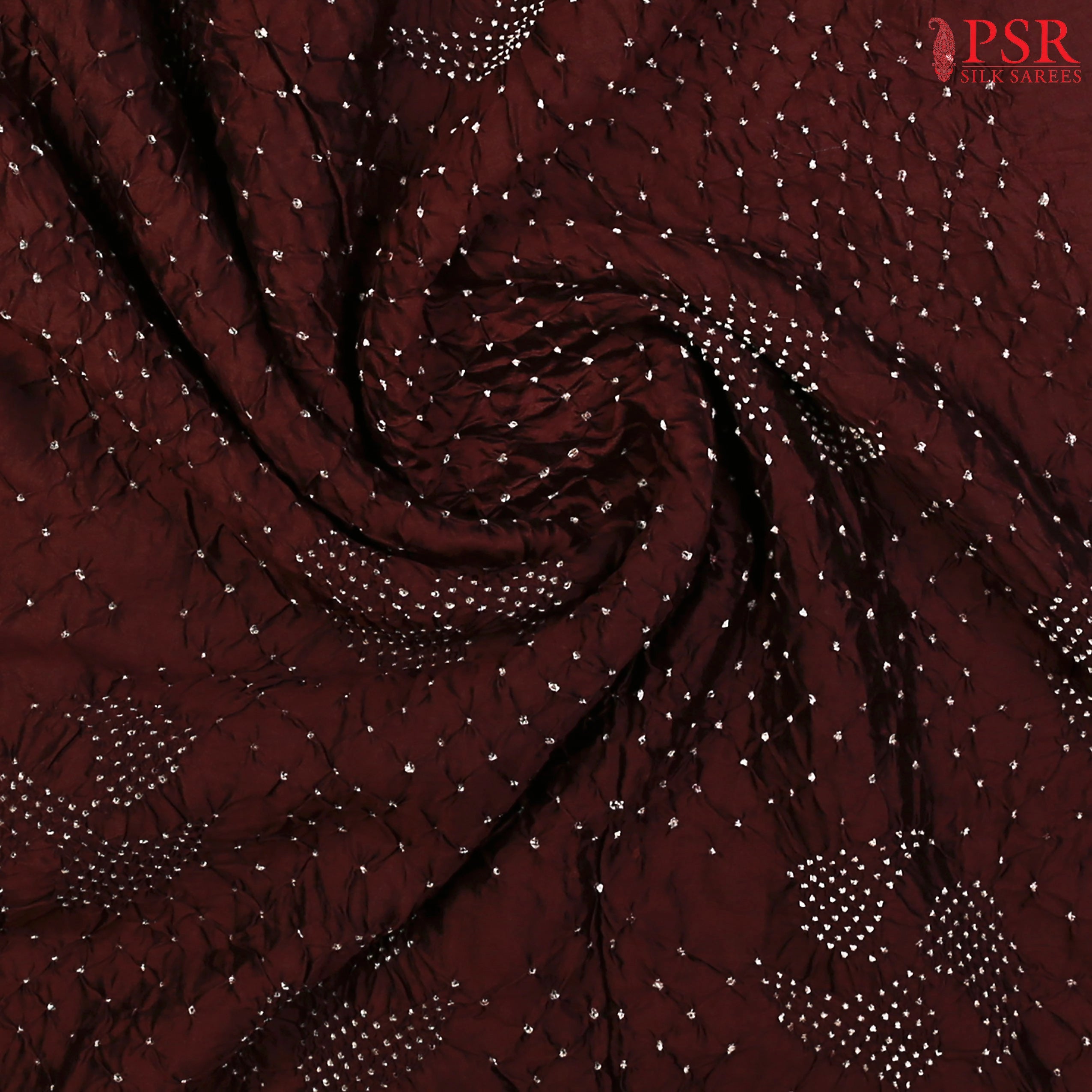 Delicate Bandhini prints enhancing the saree’s crushed silk texture