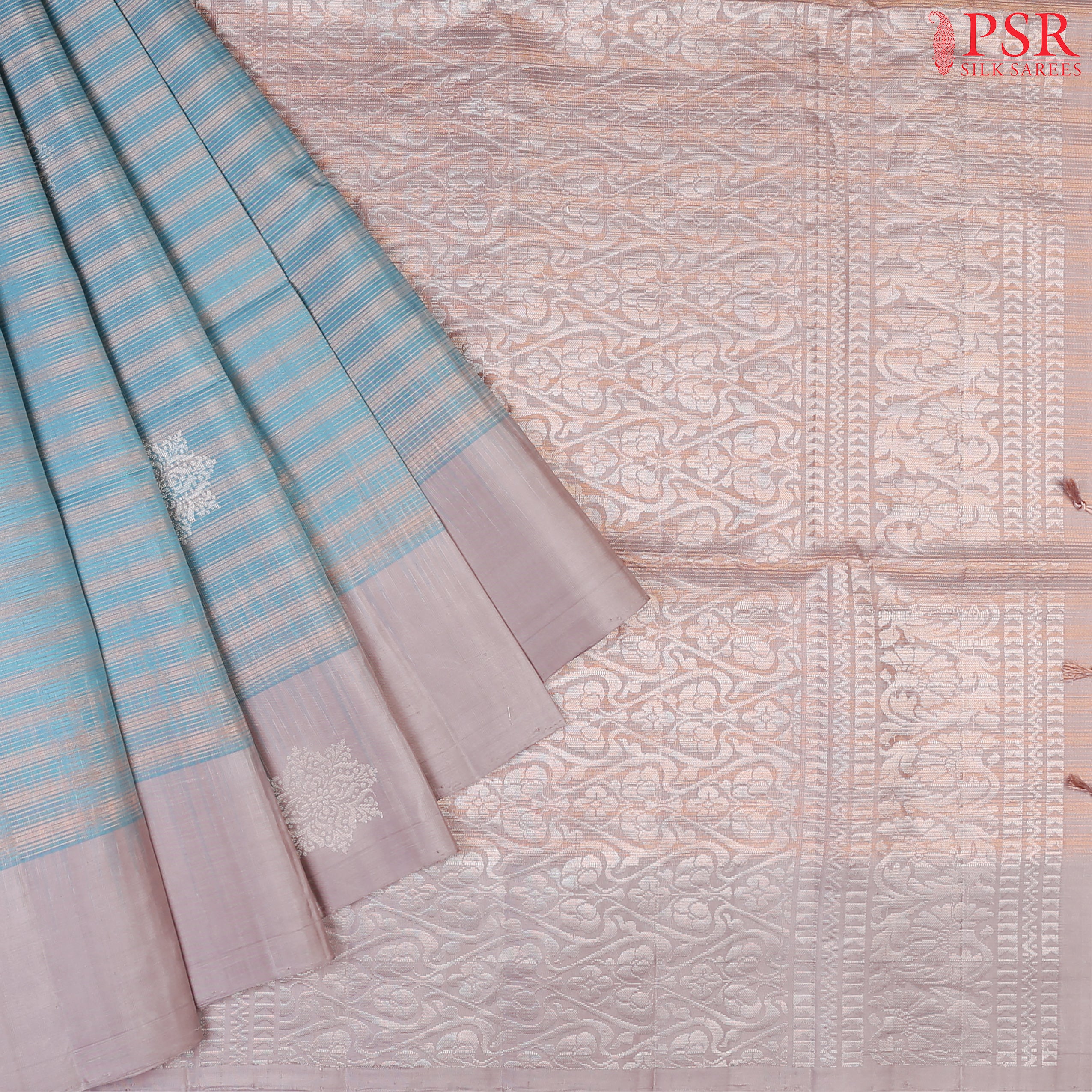 Introducing our Cerulean Blue Soft Silk Saree, an embodiment of elegance and charm. This exquisite saree is adorned with copper zari stripes and delicate silver zari floral motifs, creating a harmonious blend of tradition and modernity.