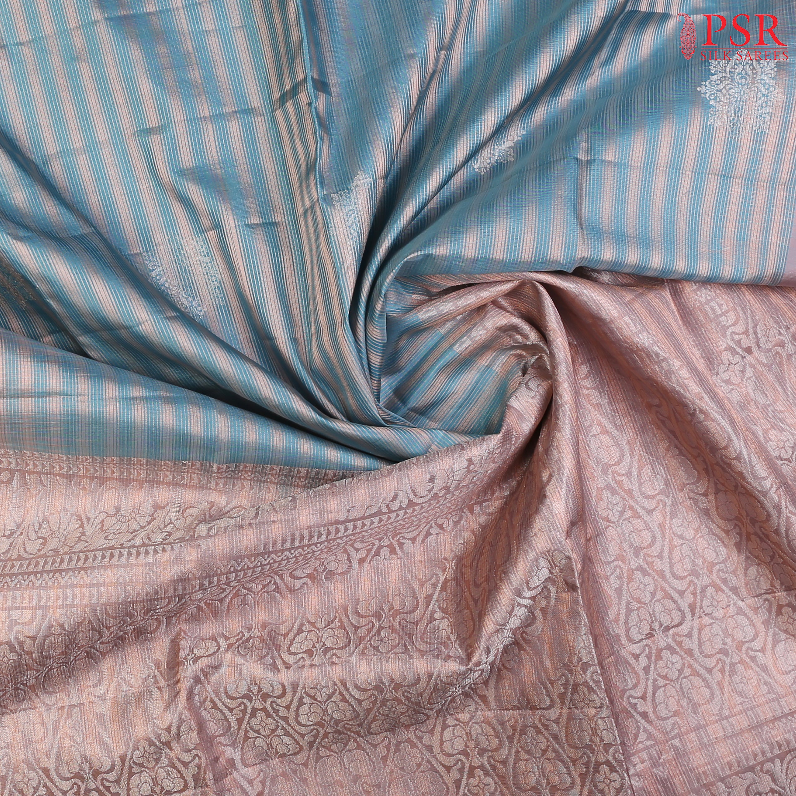 Introducing our Cerulean Blue Soft Silk Saree, an embodiment of elegance and charm. This exquisite saree is adorned with copper zari stripes and delicate silver zari floral motifs, creating a harmonious blend of tradition and modernity.