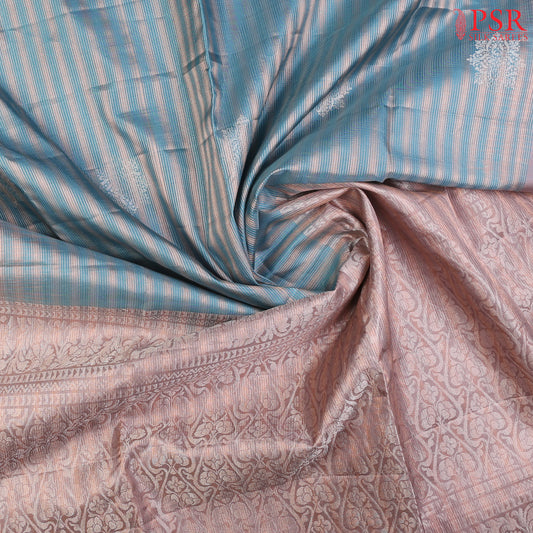 Introducing our Cerulean Blue Soft Silk Saree, an embodiment of elegance and charm. This exquisite saree is adorned with copper zari stripes and delicate silver zari floral motifs, creating a harmonious blend of tradition and modernity.