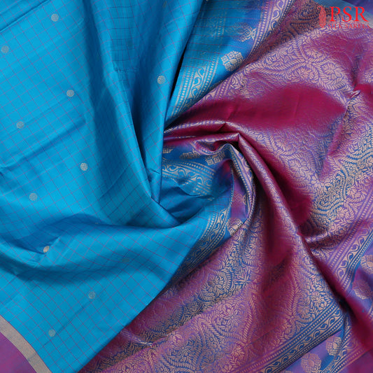 Step into regal sophistication with our Cyan Soft Silk Saree, exquisitely paired with a rich Purple contrast. 