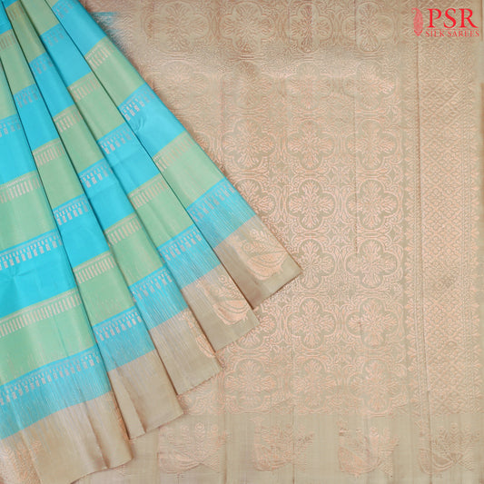 PSR Silk Sarees presents a graceful Light Blue and Light Green Soft Silk Saree, beautifully paired with a sophisticated Olive Grey accent. This saree stands out with its&nbsp;double-colored stripes, delicately woven with lustrous copper zari work, adding a touch of modern elegance.