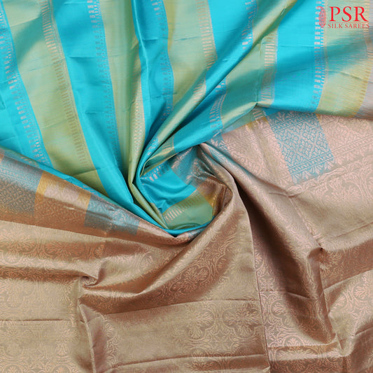 PSR Silk Sarees presents a graceful Light Blue and Light Green Soft Silk Saree, beautifully paired with a sophisticated Olive Grey accent. This saree stands out with its&nbsp;double-colored stripes, delicately woven with lustrous copper zari work, adding a touch of modern elegance.