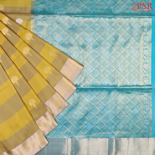 Discover the charm of tradition with a modern twist in PSR Silks' Olive Yellow Soft Silk Saree, beautifully paired with a vibrant Bright Cerulean Blue.
