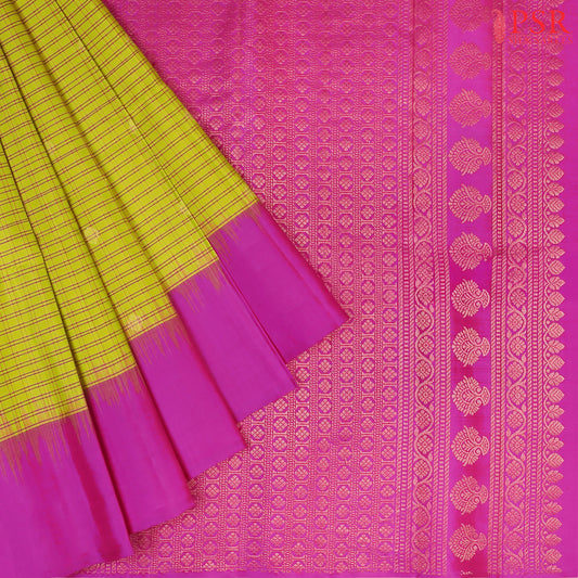 Drape yourself in the timeless beauty of our Olive Yellow Soft Silk Saree, gracefully paired with a Magenta Purple contrast. The saree features a classic checkered pattern, adorned with delicate golden zari floral motifs, adding a touch of regal charm. 
