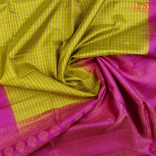 Drape yourself in the timeless beauty of our Olive Yellow Soft Silk Saree, gracefully paired with a Magenta Purple contrast. The saree features a classic checkered pattern, adorned with delicate golden zari floral motifs, adding a touch of regal charm. 