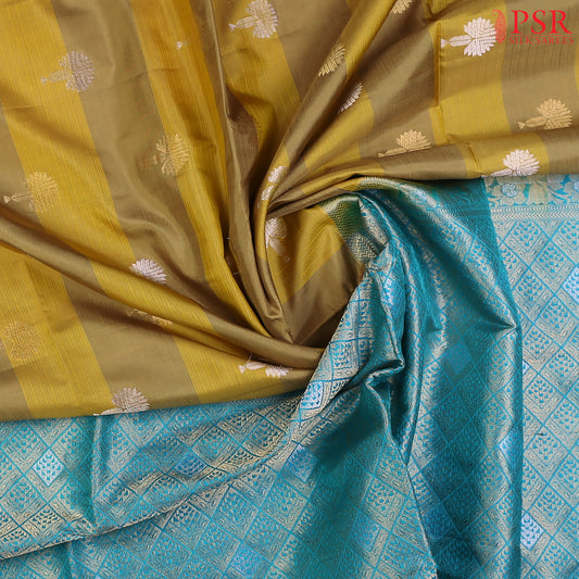 Discover the charm of tradition with a modern twist in PSR Silks' Olive Yellow Soft Silk Saree, beautifully paired with a vibrant Bright Cerulean Blue.