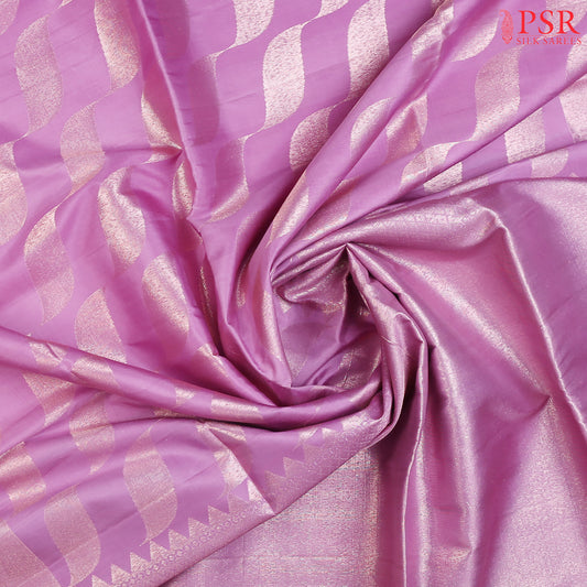 Introducing our Orchid Purple Soft Silk Saree, a stunning fusion of rich tradition and modern sophistication. This elegant saree features toned copper zari curvy tissue stripes, creating a captivating and luxurious texture that stands out in every light.