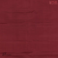 Plain Maroon silk blouse complementing the saree’s grandeur